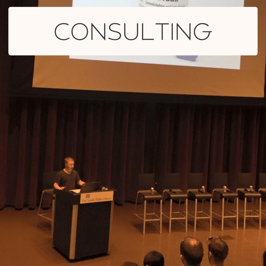 Consulting: Image of Brandyn giving a public health presentation at the Seattle Public Library in 2015. Links to Real Belonging consulting website.